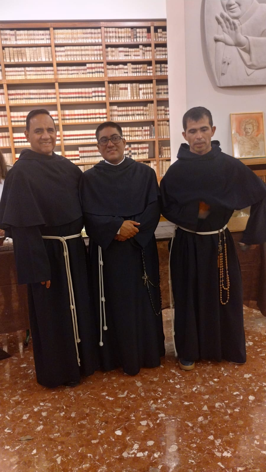 Tre frati nella biblioteca della casa religiosa
